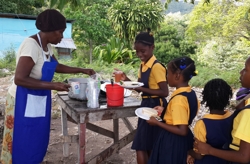 Cureen Peart from the Chester Seventh-day Adventist Church, serves students at the Chester Primary School during the breakfast-feeding programme